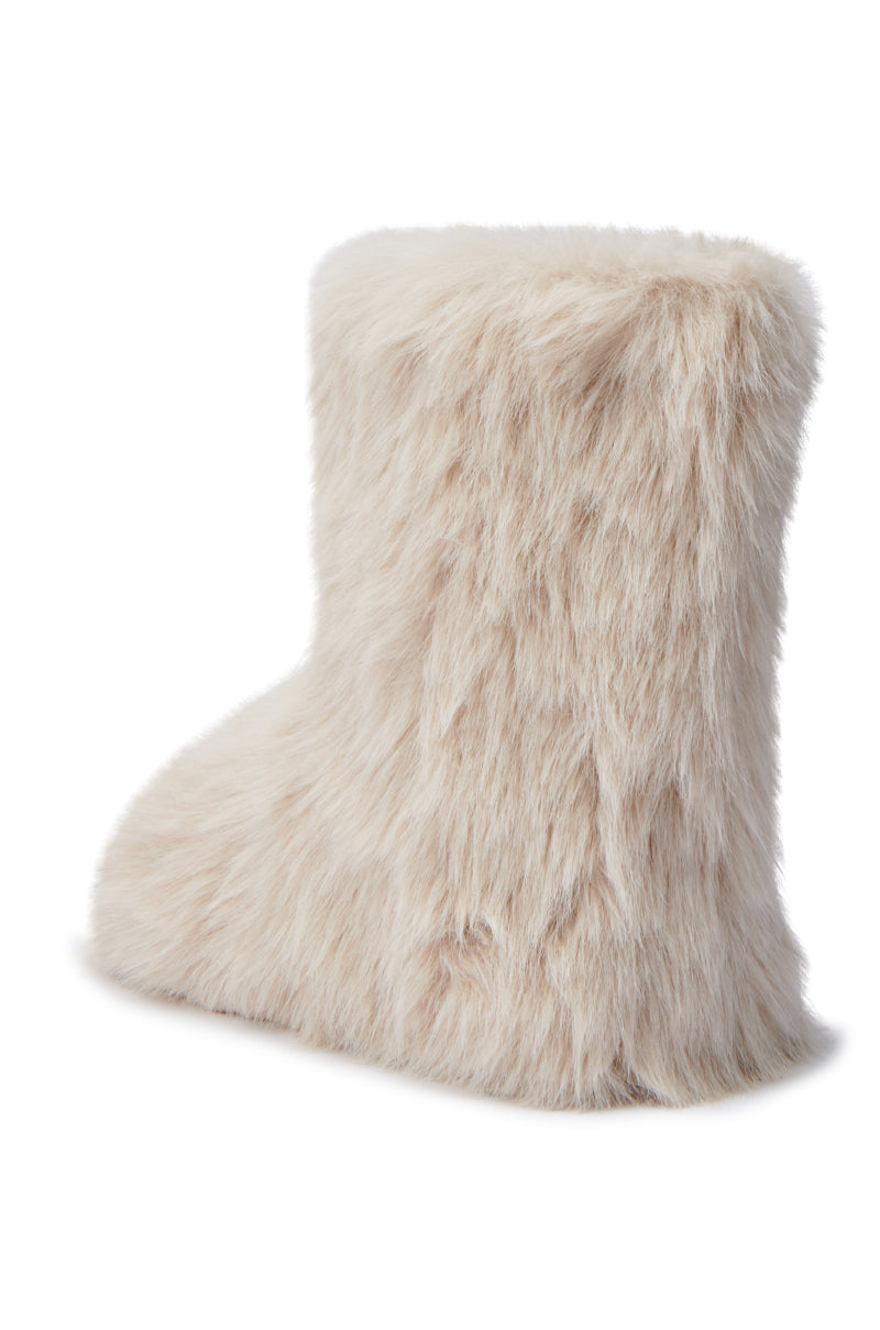 The MELANIE BEIGE FURRY BOOTIE, with its soft and fluffy faux fur texture, is showcased against a plain white background. This cozy bootie features a round toe design and flat sole.