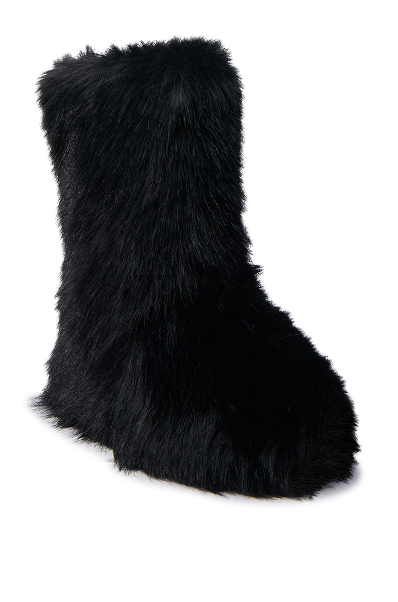 The MELANIE BLACK FURRY BOOTIE showcases a shaggy faux fur-like texture in black, contrasted against a crisp white background. This cozy bootie features a rounded toe and reaches mid-calf height, making it an ideal choice for chilly days.