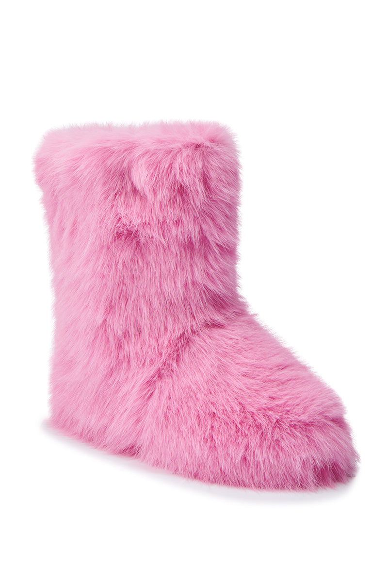 A side view of the MELANIE PINK FURRY BOOTIE showcases its pink faux fur texture and cozy sherpa lining against a white background, featuring a flat sole that looks incredibly warm and inviting. 4
