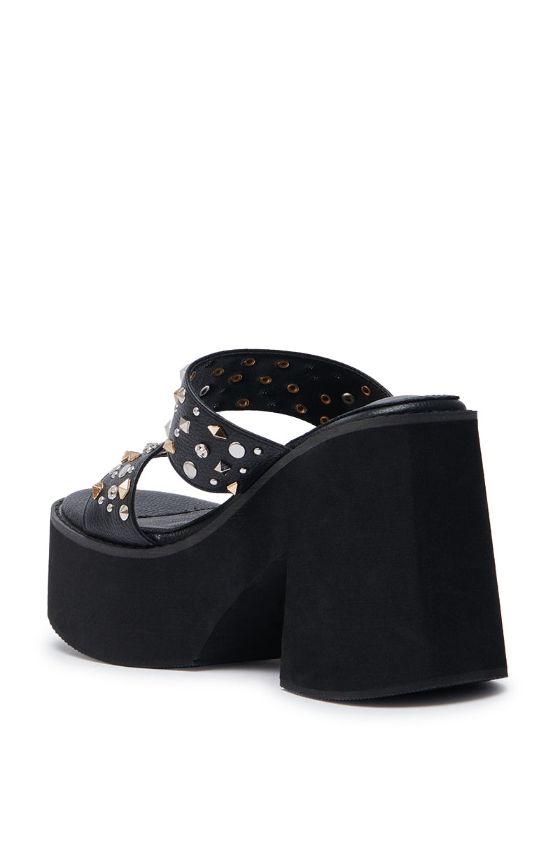 The AZALEA WANG MIKAEL Black Chunky Slip On Sandal features a platform sole, crisscross faux leather straps with metal studs, and an open toe for a bold, modern look.