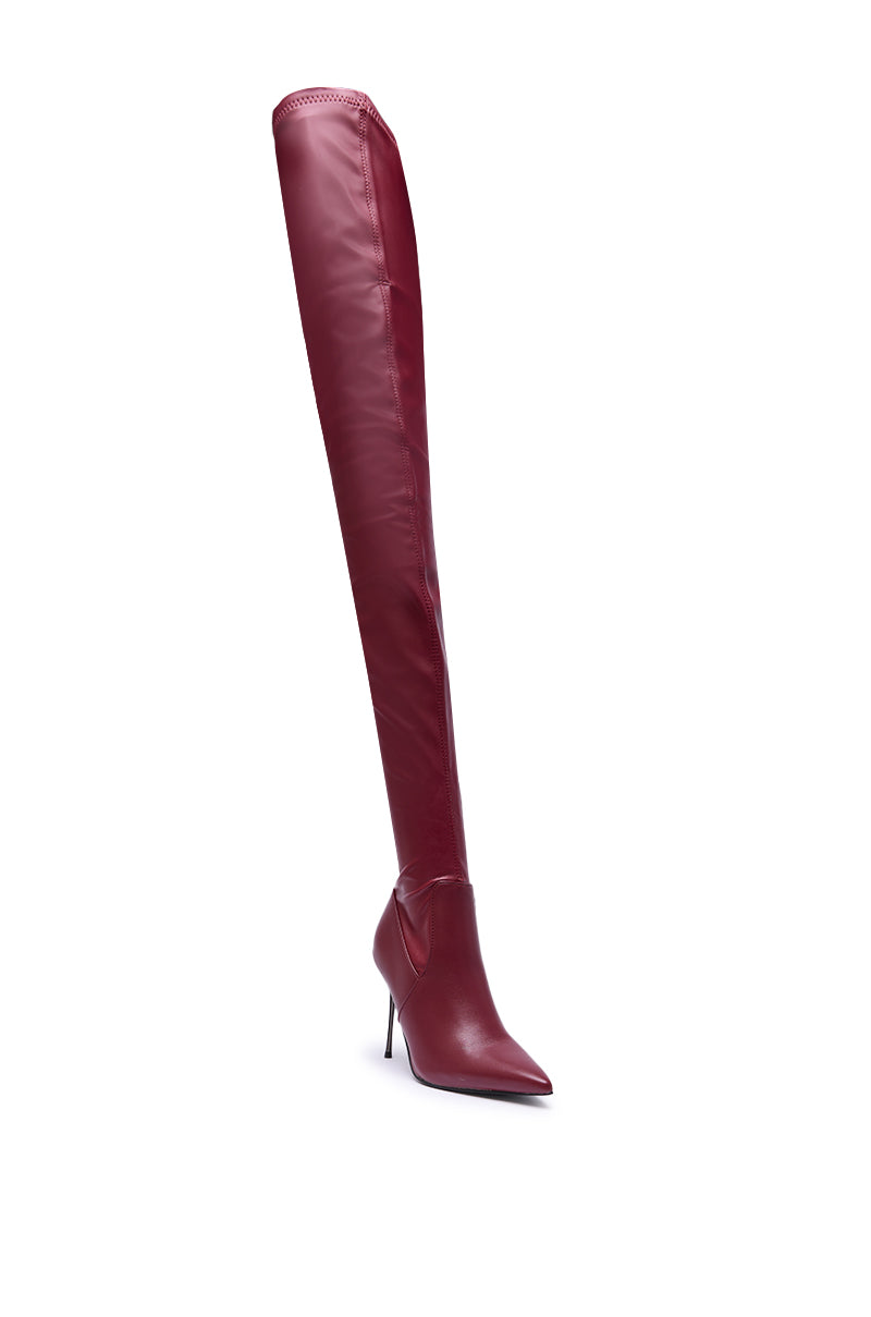 The AZALEA WANG MILANDRA BURGUNDY STRETCH PU THIGH HIGH BOOT features a maroon faux leather finish, pointed toe, and stiletto heel, shown upright against a white background.