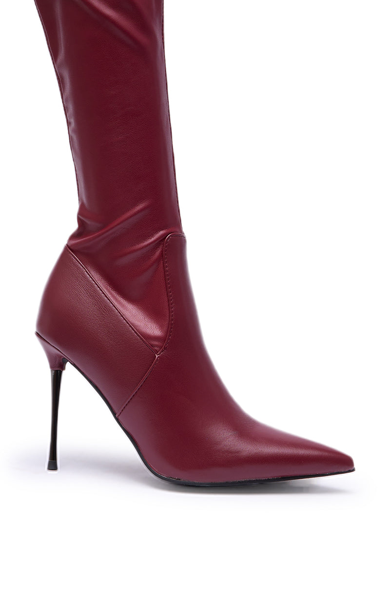 A close-up of the AZALEA WANG MILANDRA Burgundy Stretch PU Thigh High Boot, featuring shiny faux leather, a pointed toe, and a thin stiletto heel, displayed against a white background.