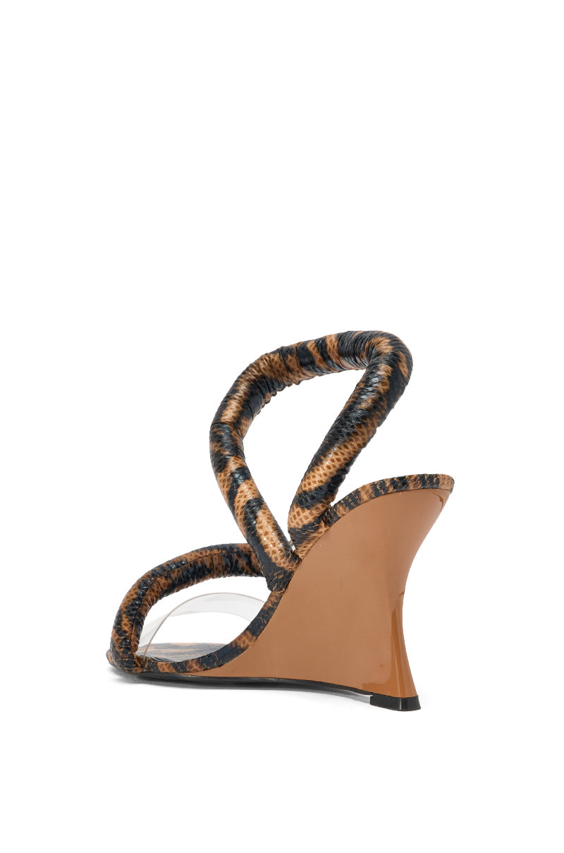 The AKIRA MINORU BROWN ANIMAL PRINT WEDGE SANDAL features a brown wedge heel, snakeskin-embossed straps, and an open toe, displayed from the back on a white background. 4