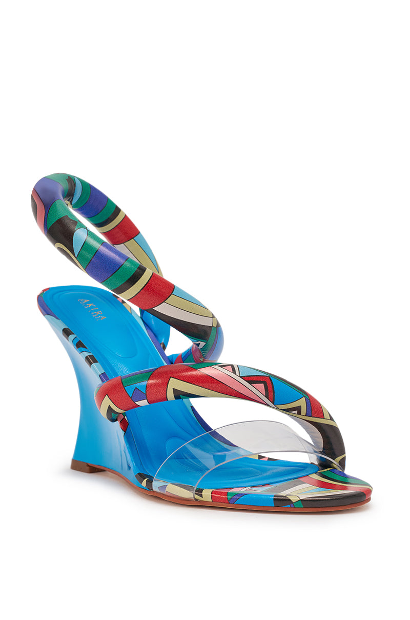 The AKIRA GOLD MINORU MULTI PRINTED WEDGE PUFF SANDAL features a blue wedge, clear toe strap, and multicolored geometric straps—including a swirling ankle strap—for an art-pop look that makes a bold statement. 5
