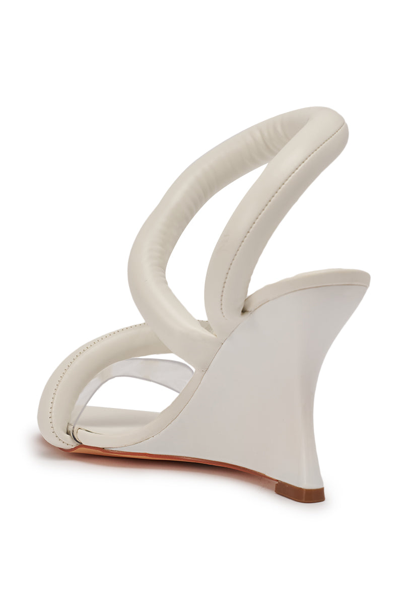 The AKIRA MINORU WHITE WEDGE SANDAL features a modern design with two thick padded straps, a clear front band, and a sculptural curved wedge heel, displayed from the rear against a white background. 8