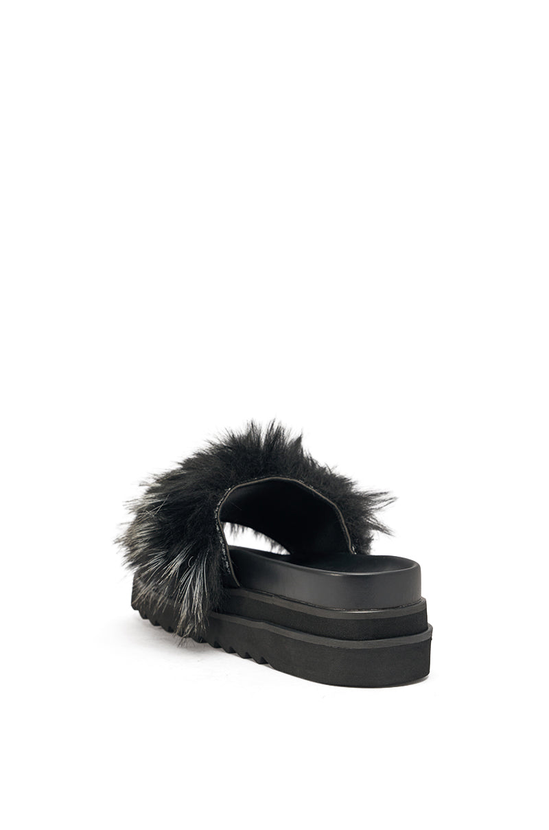 The AKIRA MIRAY BLACK MULTI BLACK FUR SLIDE is a black faux leather platform sandal featuring a chunky sole and a wide strap adorned with black and gray faux fur, displayed from a rear side angle on a white background. 5