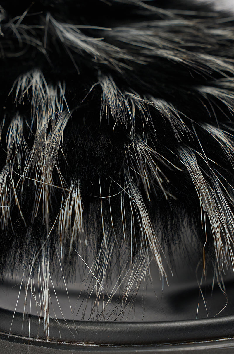 Close-up of the AKIRA MIRAY BLACK MULTI BLACK FUR SLIDE: black fur with white and gray strands, showing a soft texture. The curved, dark faux leather platform sole is visible at the bottom of the image. 6
