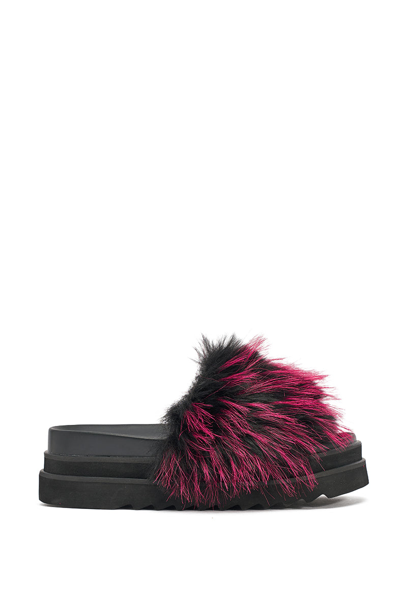 The AKIRA MIRAY PINK MULTI FUR SLIDE is a black faux leather platform sandal with a wide strap adorned in fluffy black and bright pink faux fur, inspired by Y2K style. 4