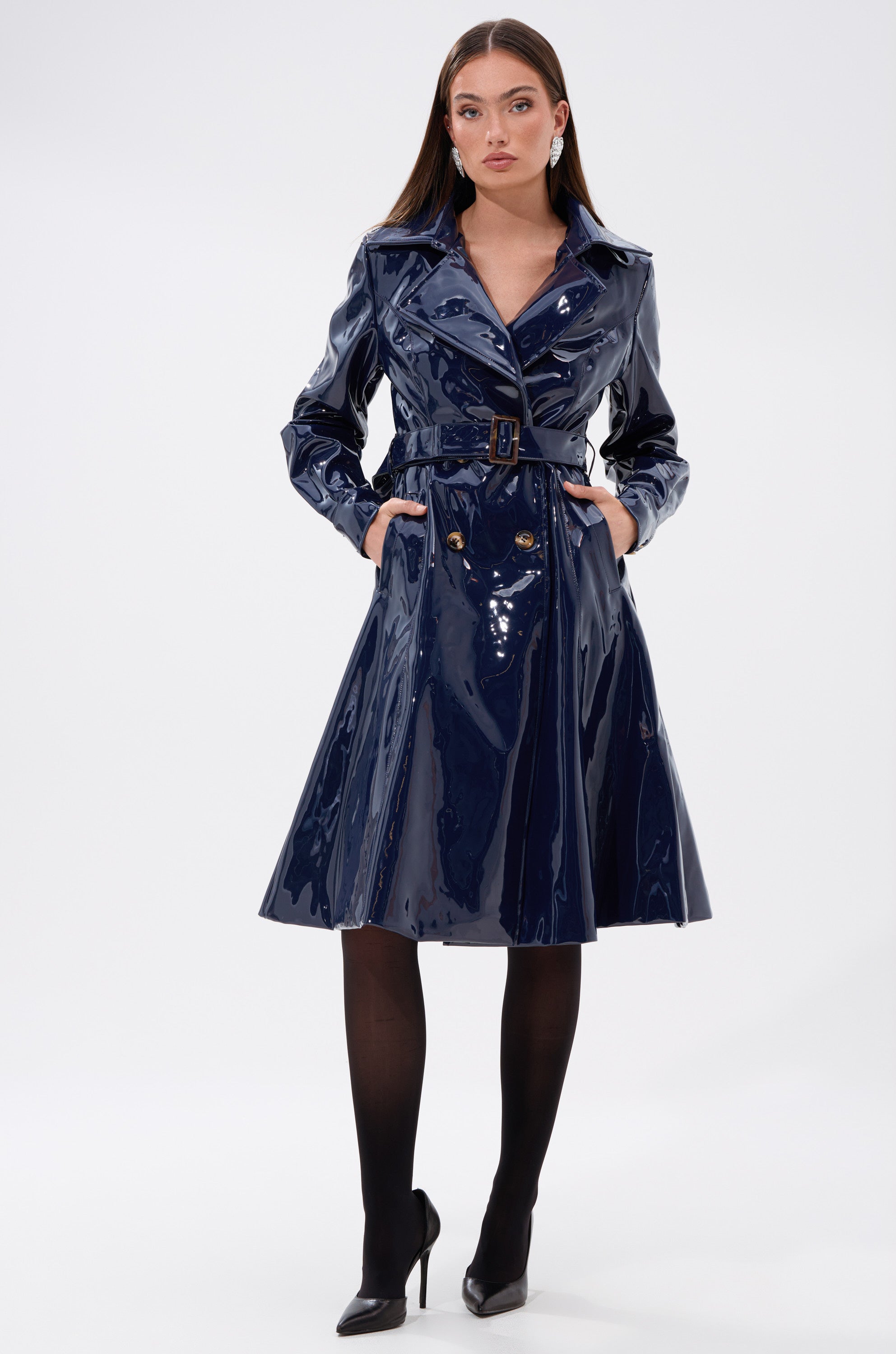A woman in the MITICA PATENT TRENCH IN NAVY from AKIRA Label.