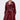 A woman models the MITICA PATENT TRENCH COAT—shiny dark red faux patent leather with double-breasted buttons—standing against a plain light background, accessorized with gold jewelry and looking directly at the camera.