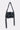 Inspired by moto style, the JORDY STUD PURSE is a structured black faux leather shoulder bag with silver studs, buckle closure, grommet strap details, hanging decorative straps, and a shiny finish.
