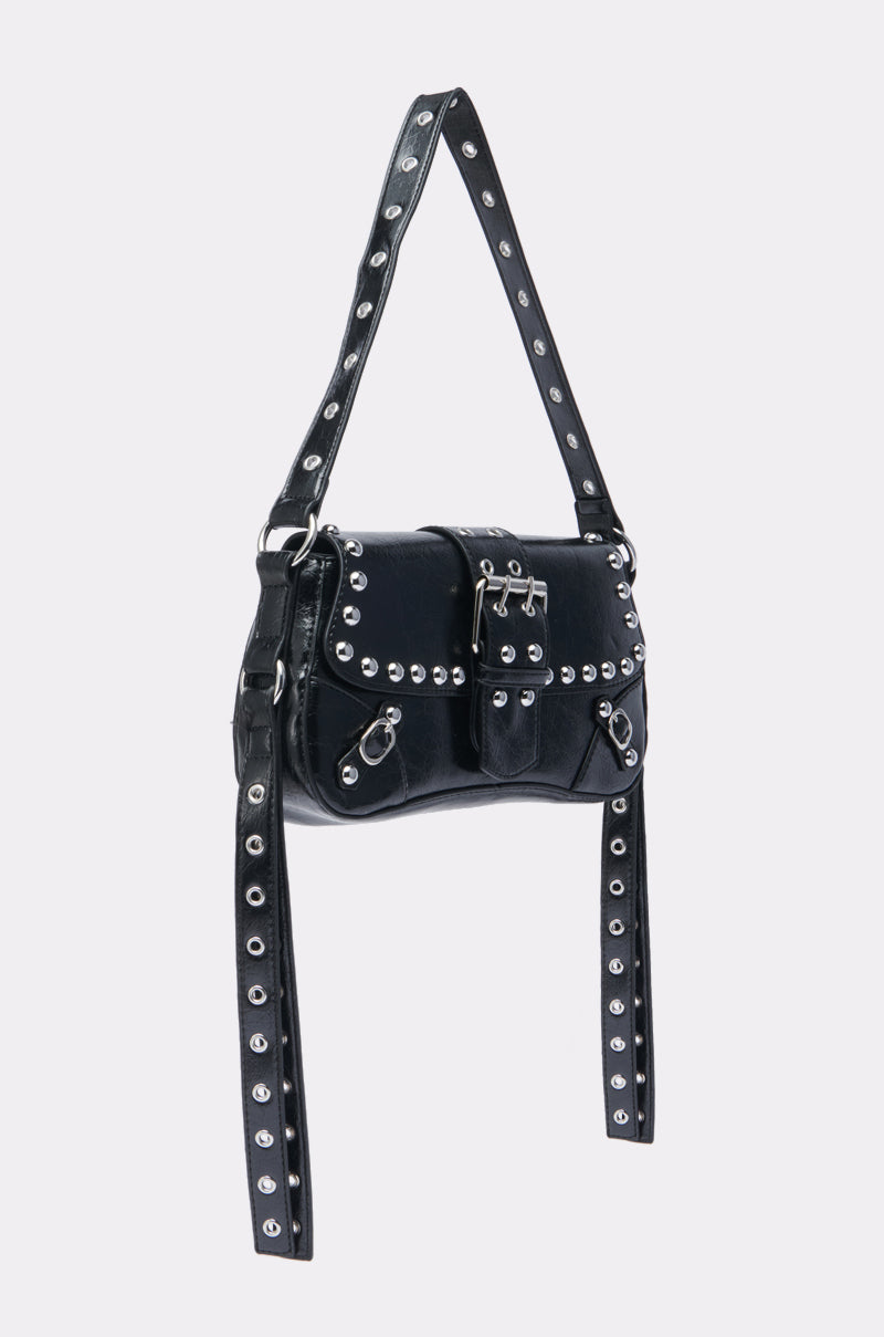 Inspired by moto style, the JORDY STUD PURSE is a structured black faux leather shoulder bag with silver studs, buckle closure, grommet strap details, hanging decorative straps, and a shiny finish. 2