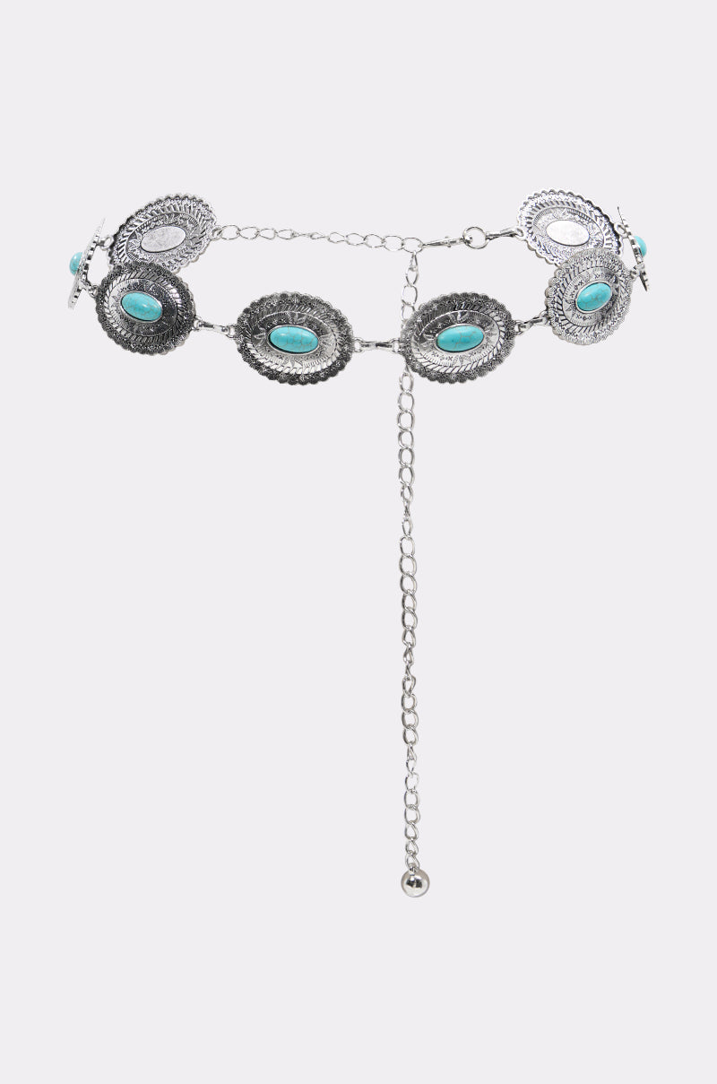 The LETS ROCK CHAIN BELT features oval silver engraved plates, each set with a turquoise stone, linked together and finished with an adjustable chain and dangling end.