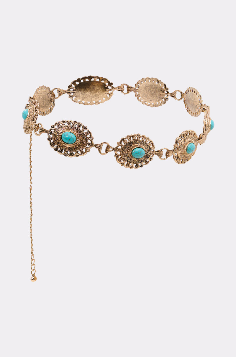 The WITH IT CHAIN BELT features ornate gold oval medallions with central turquoise stones and a dangling adjustable chain clasp—an ideal Western-inspired accessory.