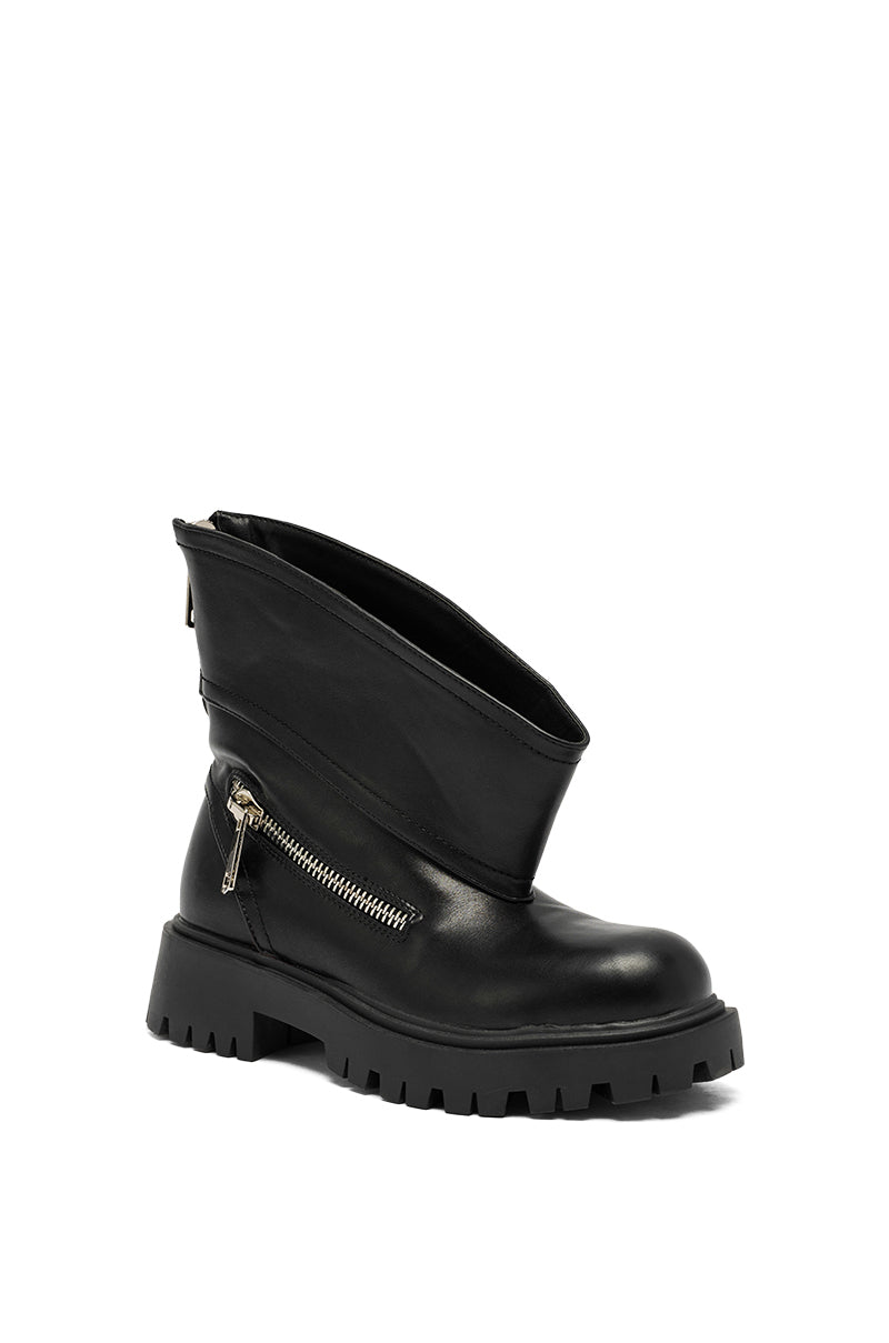 The AZALEA WANG MOHSEN BLACK COMBAT BOOTIE features faux leather, a chunky treaded sole, wide folded-over upper, side zipper detail, and back zipper, all shown in black against a white background.