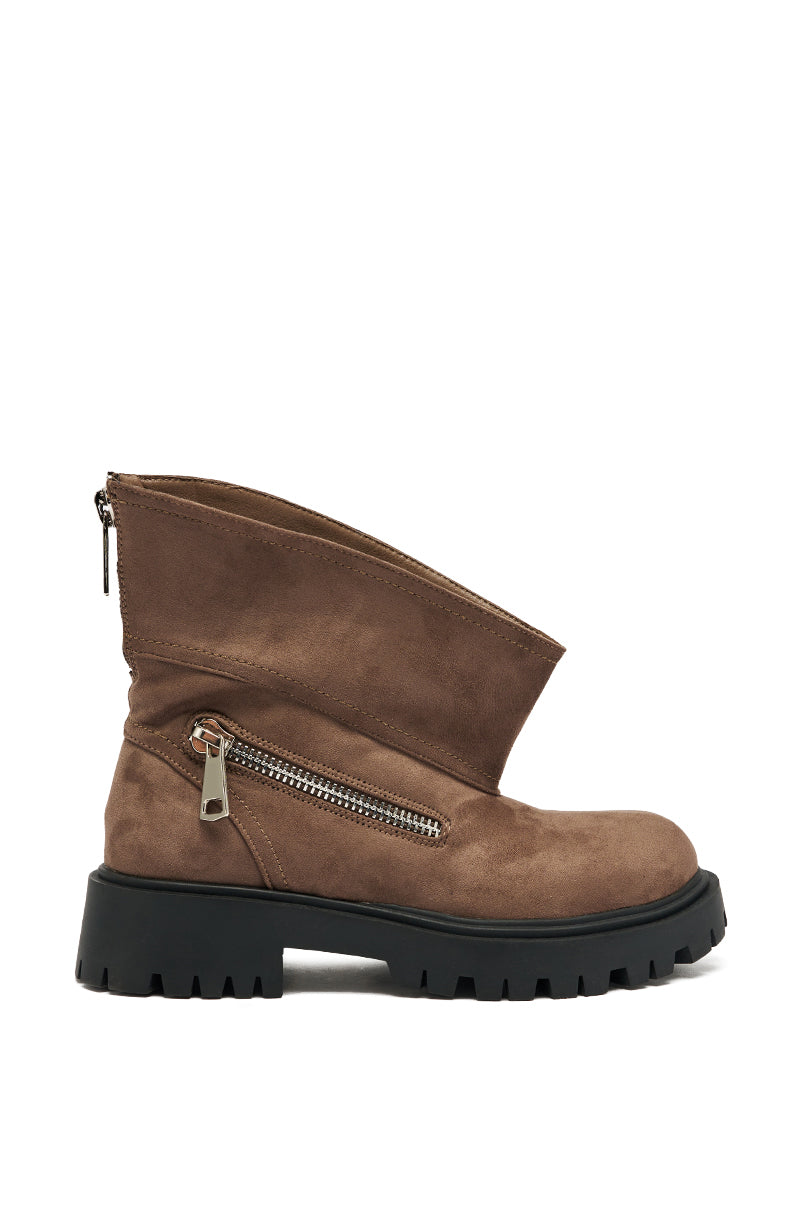 The AZALEA WANG MOHSEN MOCHA COMBAT BOOTIE features brown faux suede, a chunky black heel, side zipper, slanted upper design, and exposed zipper detail for a rugged, modern look.