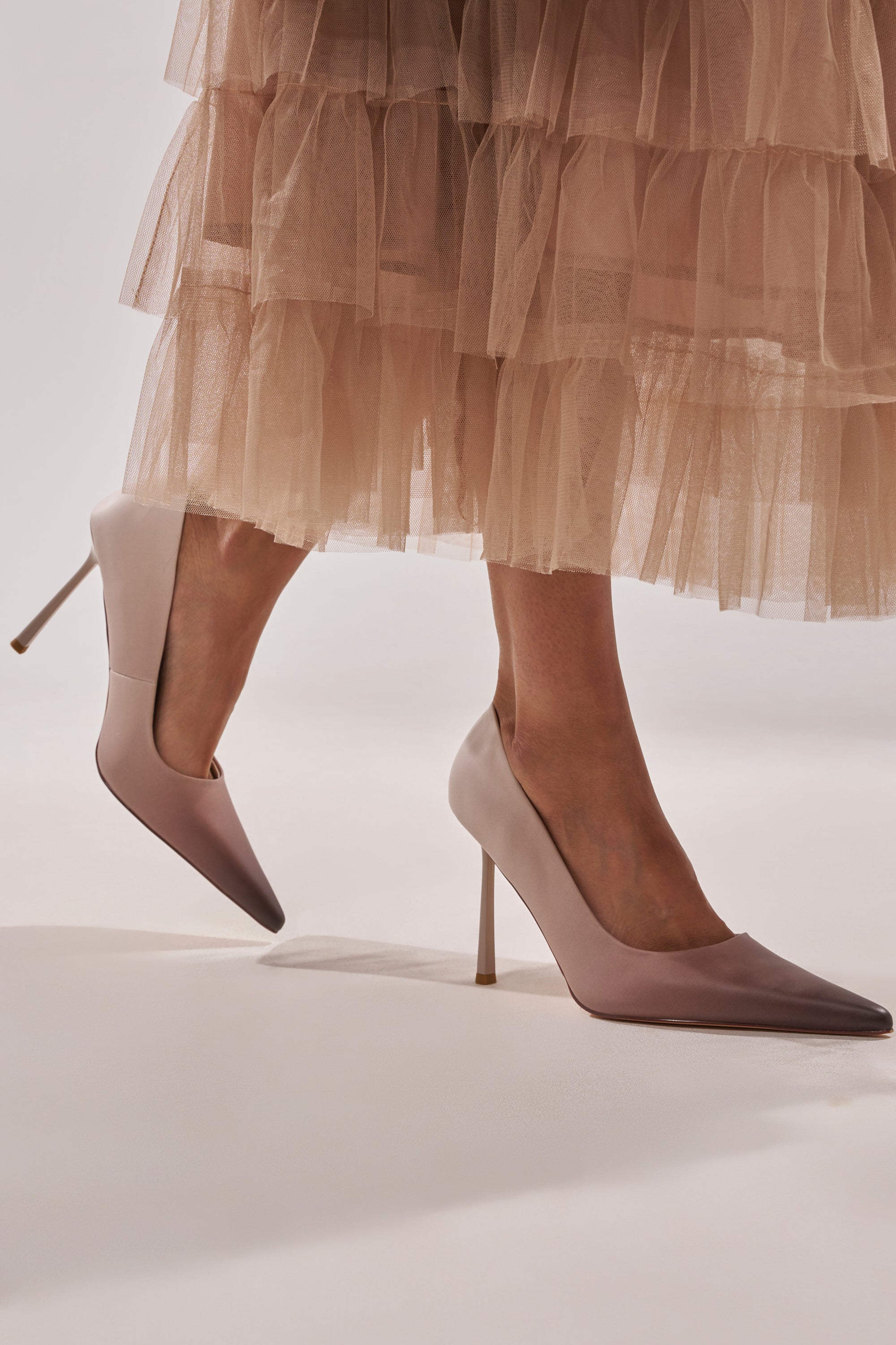 A person wearing the AZALEA WANG BROWN OMBRE EFFECT STILETTO PUMP and a soft beige, layered tulle skirt stands against a light background. 0