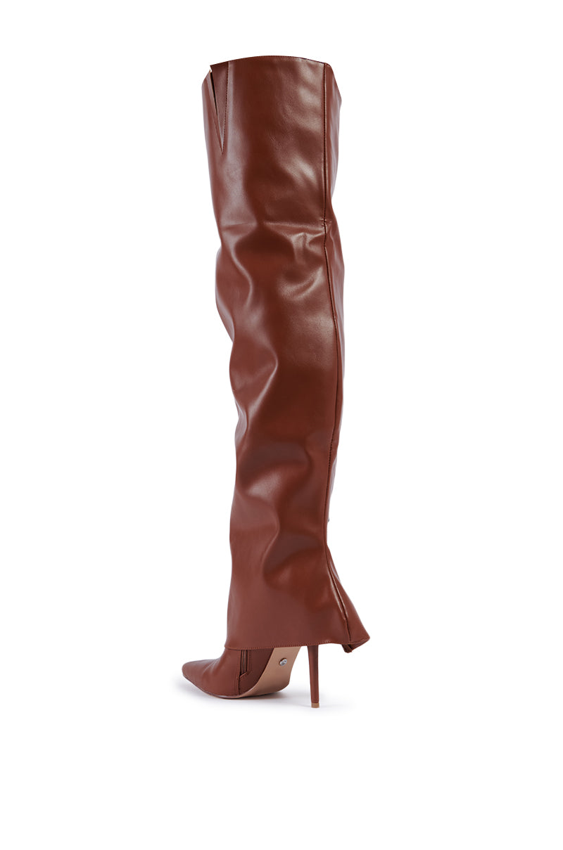 The AZALEA WANG MOSSY TAN BOOT, a single thigh-high stiletto boot in brown leather, features a pointed toe and a smooth, slightly wrinkled texture. Displayed against a white background, its slim and high heel adds to the elegant design. 5
