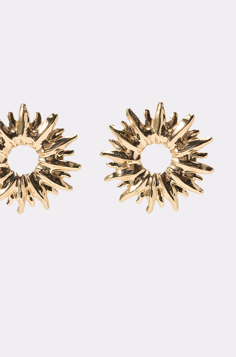 The SUNBURST EARRING features two metallic gold earrings with open centers and a textured finish, shown on a plain light background—perfect as summer wedding accessories. 3