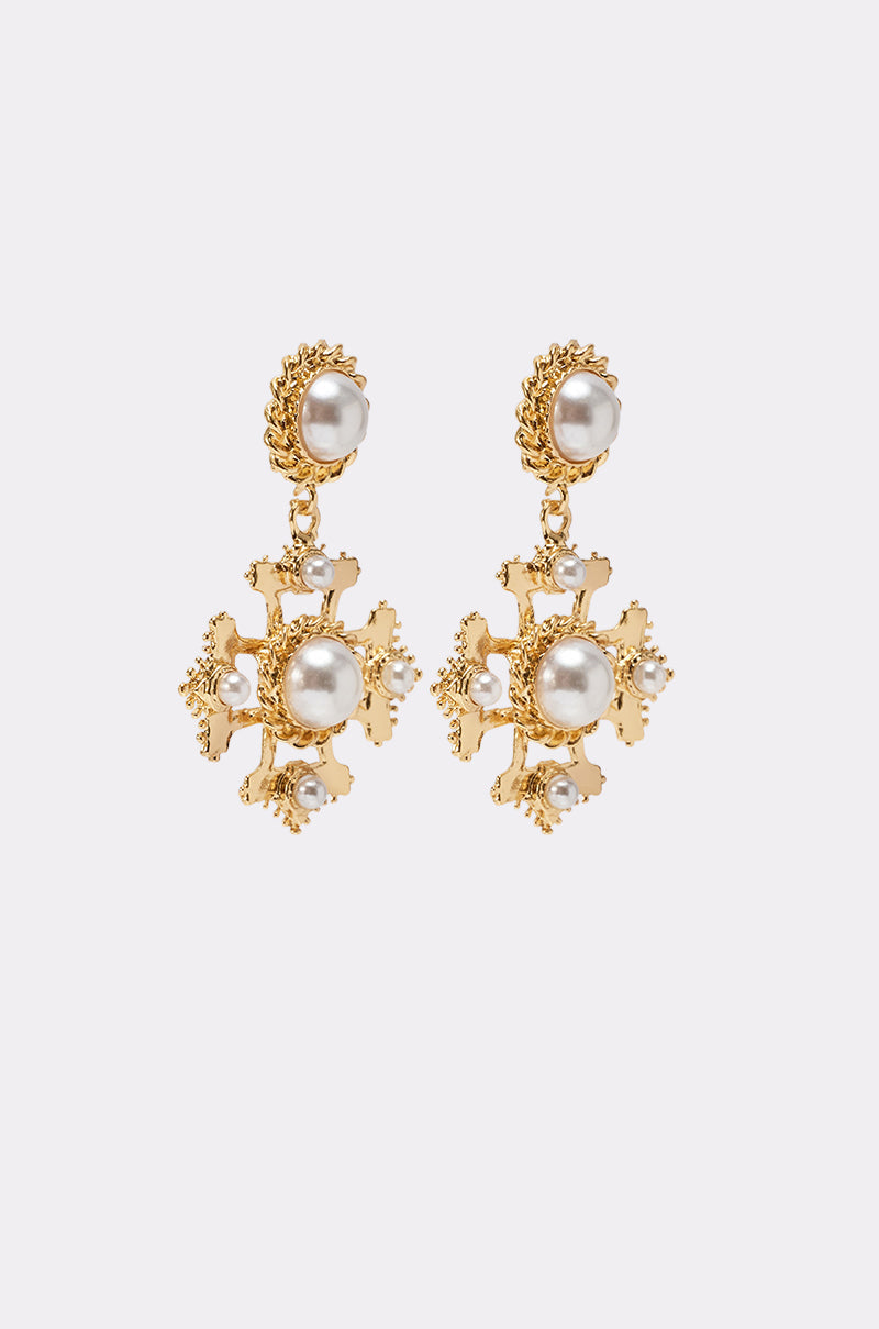 The CROSS MY HEART EARRING features gold dangle earrings with intricate floral designs, large white pearls at the center, and smaller pearls along the edges, set against a plain light background. 3