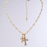 The CROSSES NECKLACE is a faux gold piece with a delicate chain of small links, featuring a rhinestone cross pendant adorned with white stones. It includes an adjustable length, extension chain, and clasp, all on a plain light gray background.