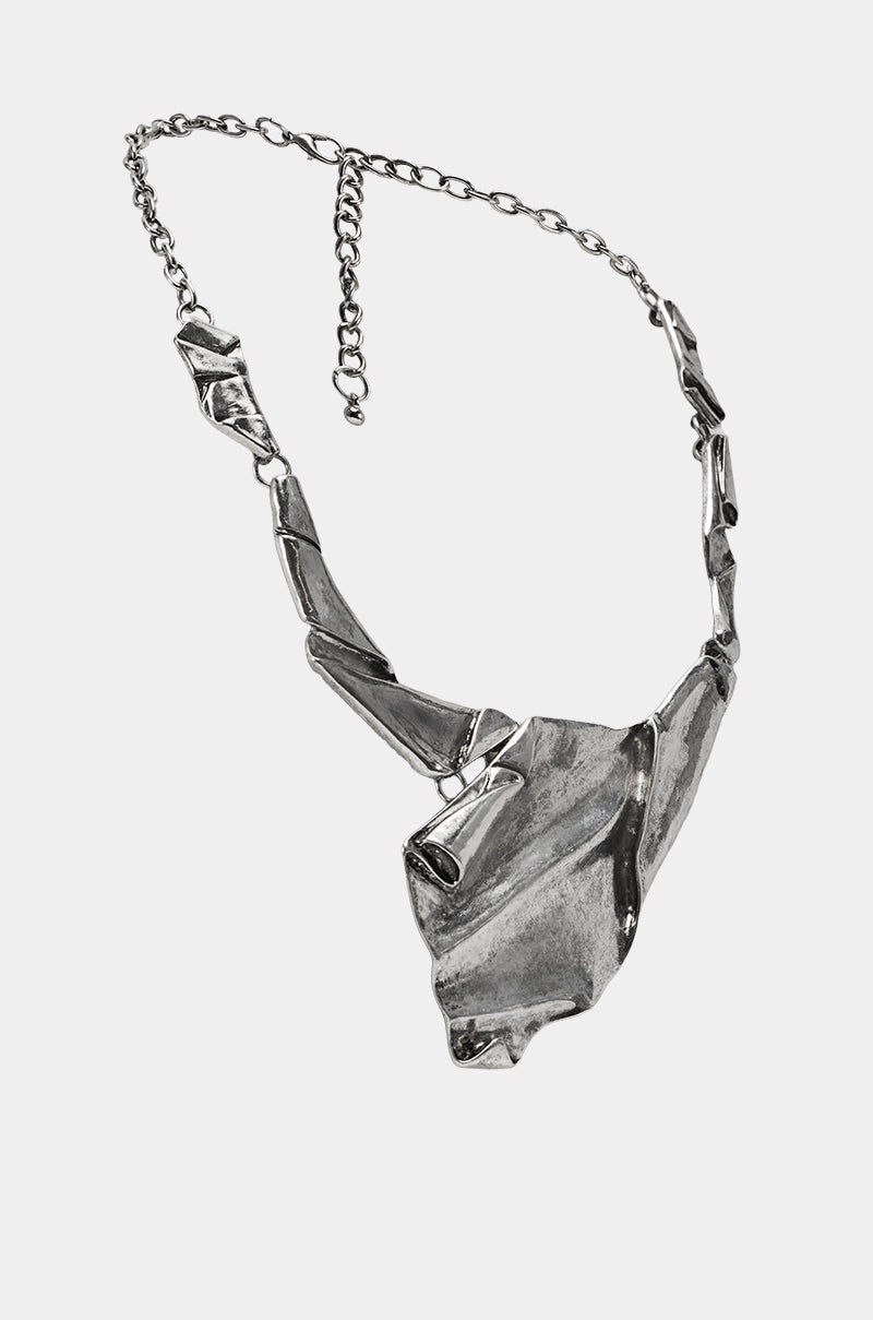 The BENT OUTTA SHAPE NECKLACE is a silver metallic statement piece with an abstract geometric design, featuring a chunky asymmetrical pendant and mixed solid angular segments on an adjustable chain. 2