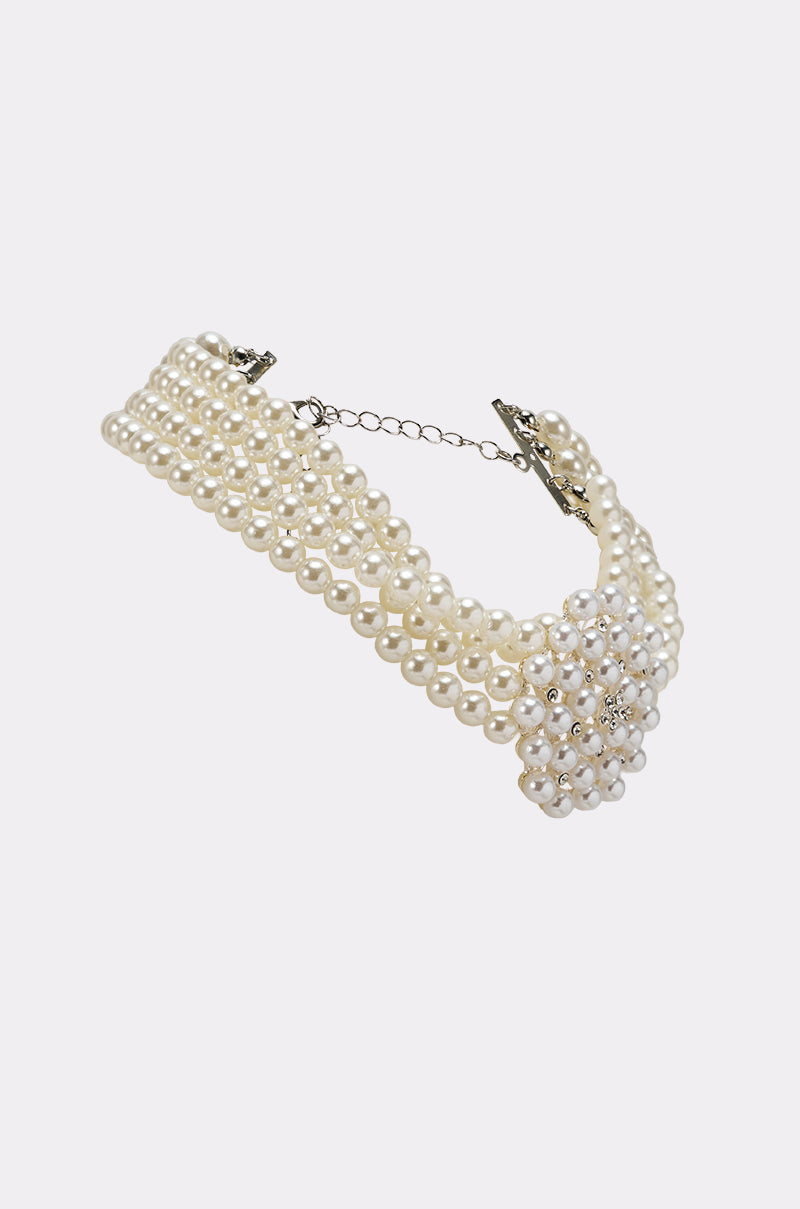 The TRULY PEARL CHOKER is a multi-strand necklace with faux pearls, a floral pearl cluster centerpiece accented by rhinestones, and an adjustable metal clasp, all showcased on a plain white background. 4