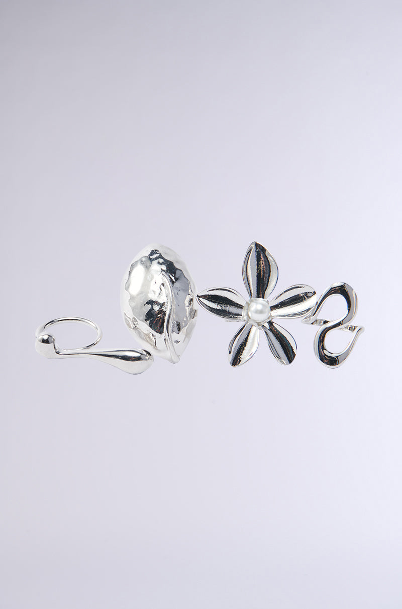A faux silver earring with an abstract, organic design featuring a textured oval and a six-petal flower with a central pearl, showcasing artistry reminiscent of modern sculptural styles found in bold pieces like the ALL THE POWER RING SET.