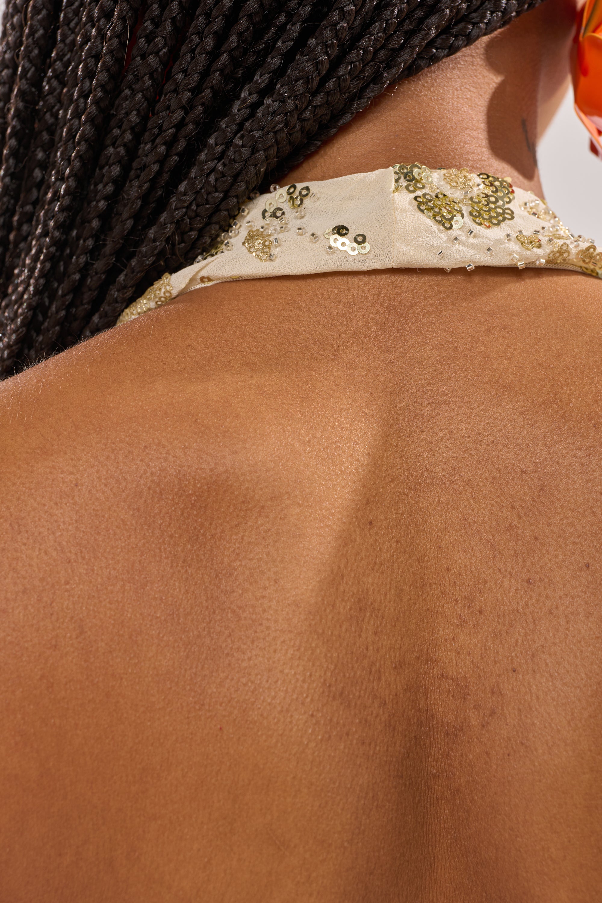 A close-up of a woman's back featuring the JULIE Baby Yellow Halter Top with Sequin—ideal for club outfits or festival styling. 6