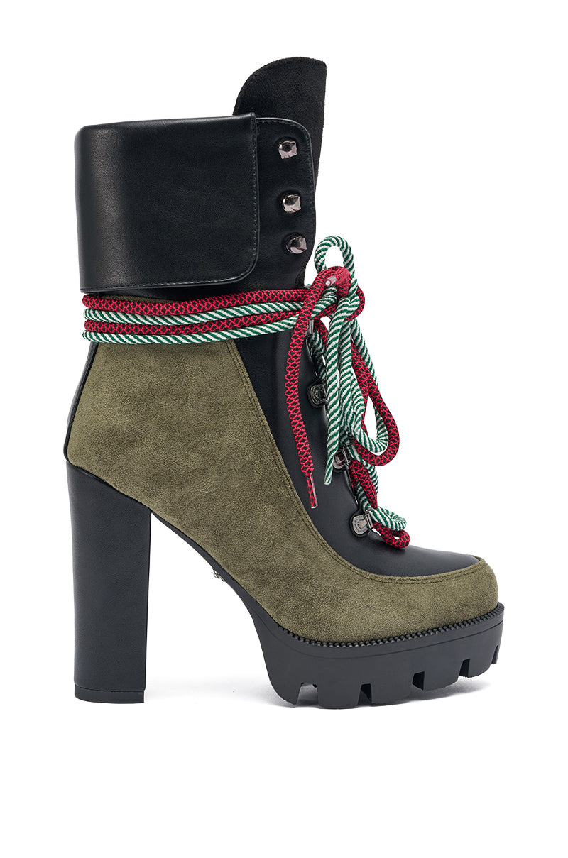 The AKIRA GOLD MUFFLER GREENMULTI CHUNKY HEEL BOOTIE features a platform lug sole, olive green suede, black faux leather upper, and red and green rope laces wrapped around the ankle with metal eyelets.