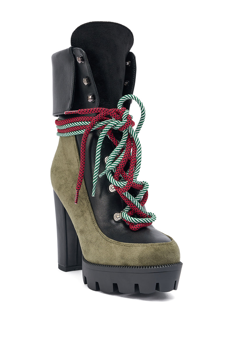 Step out in style with the AKIRA GOLD MUFFLER GREENMULTI CHUNKY HEEL BOOTIE, featuring a green faux suede upper, bold red and green striped laces, metal eyelets, and a high chunky lug sole heel for standout rugged flair.