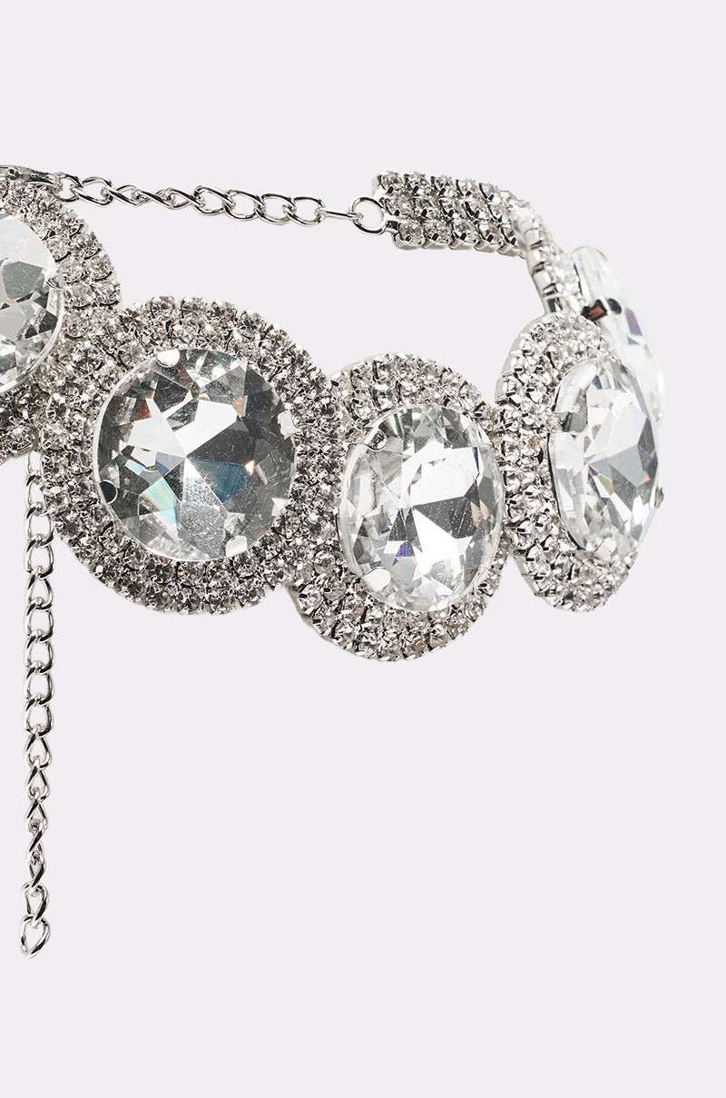 A close-up of the AT THE BALL CHOKER, showcasing large round clear gemstones encircled by smaller rhinestones and an adjustable chain clasp—an elegant accessory perfect for eveningwear. 4