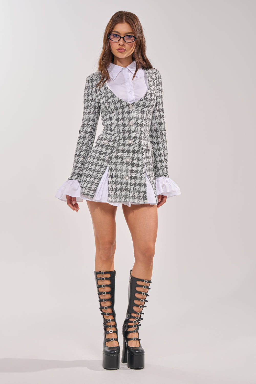 A woman wears the TALIA TWEED LONG SLEEVE COLLARED DRESS with white cuffs, black platform lace-up boots, and glasses, standing against a plain light background. 6