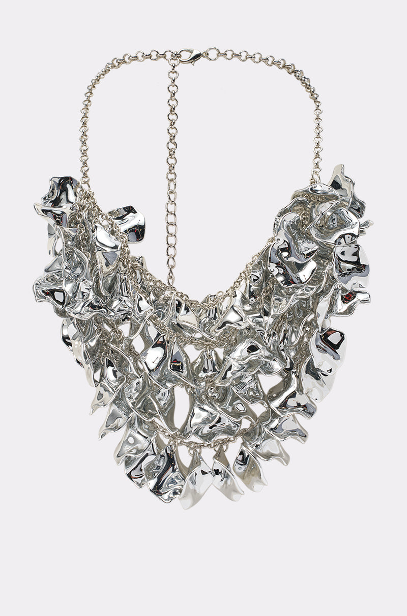 Introducing the CHECK IT OUT NECKLACE: a chunky, sculptural silver statement piece showcasing bold, irregular jagged metallic shapes linked together in an avant-garde design. This necklace is completed with a chain and clasp at the back for easy fastening.