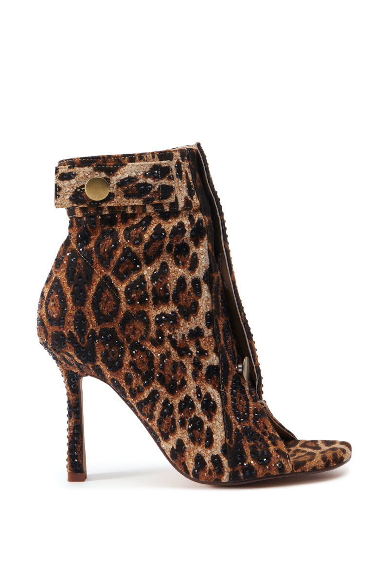Introducing the AZALEA WANG NAILY CHEETAH BUTTON UP BOOTIE: This chic cheetah print bootie boasts cut-out sections on the sides and front, complemented by an ankle-high design with a stylish strap and gold button detailing at the top. The stiletto heel is wrapped in matching fabric, and a comfort cushion insole ensures ease with every step. 2