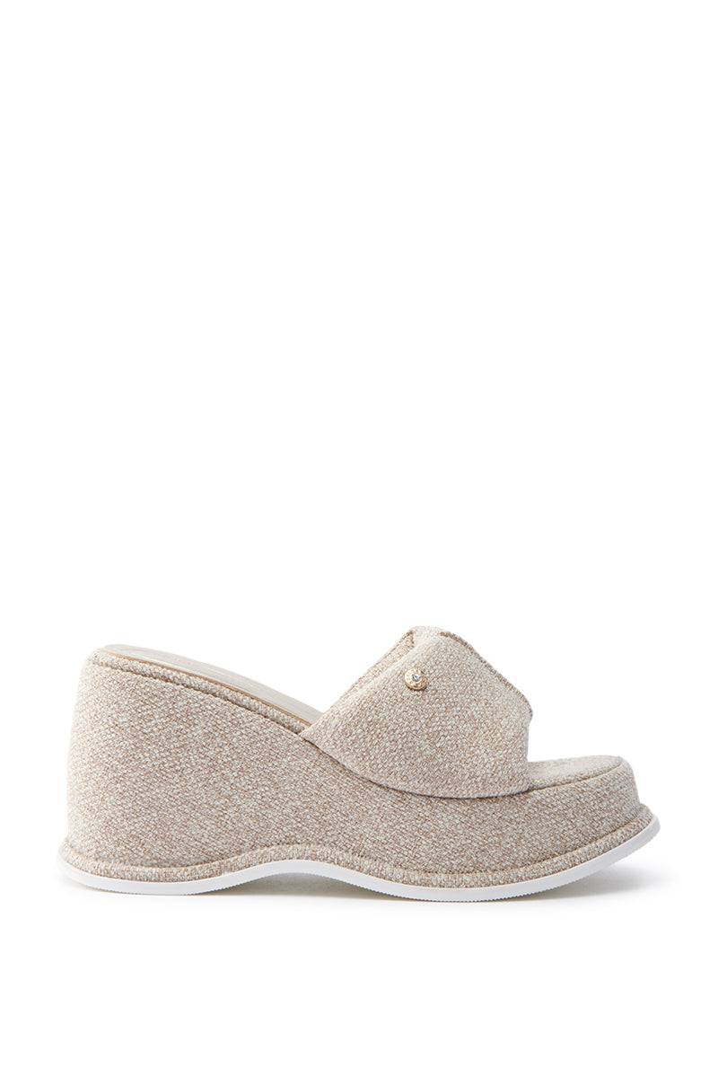 A side view of the AZALEA WANG NATHALIA Beige Novelty Flatform Sandal reveals a textured finish, covered wedge heel, small decorative stud on the upper, cushioned insole, and a platform sole with a slightly curved design and white bottom edge.