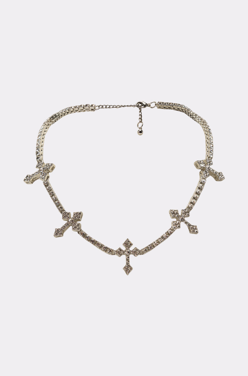 The LUXE NECKLACE is a striking silver rhinestone piece with five diamond-studded cross pendants spaced along the chain and an adjustable clasp, making it perfect for statement layering. 0