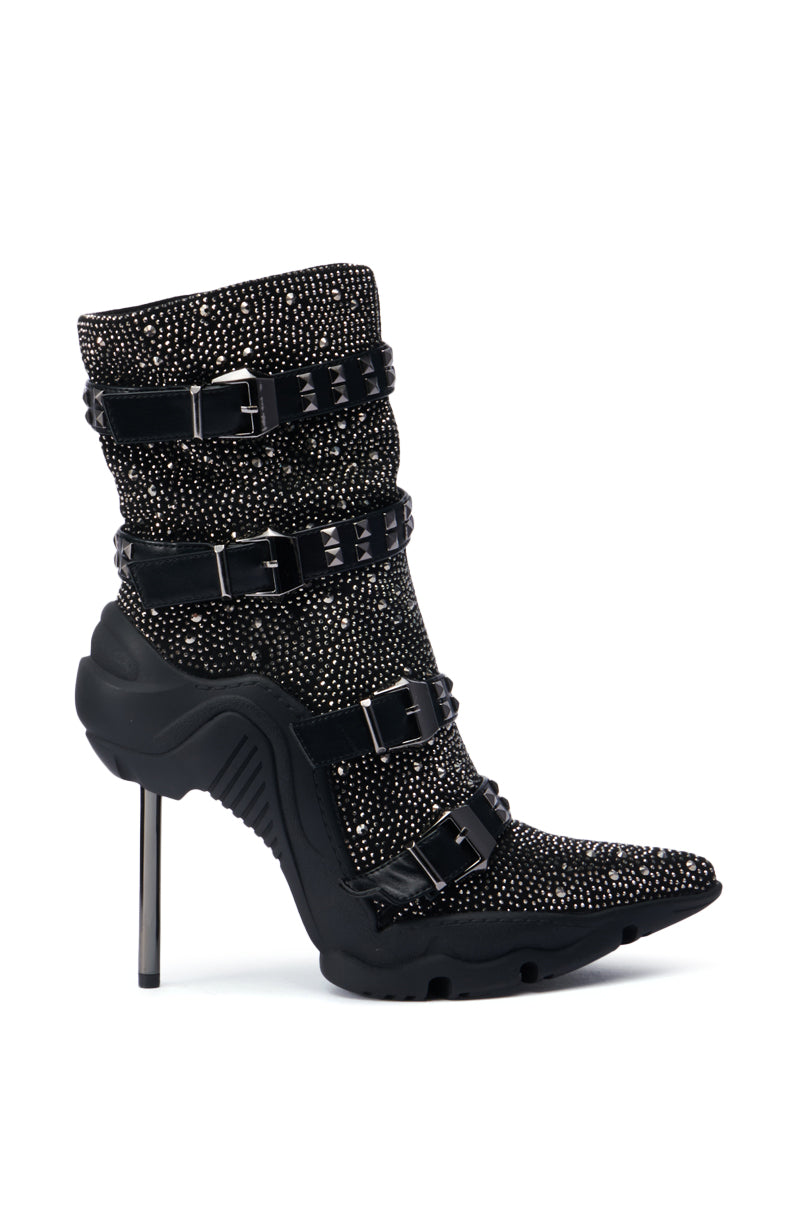 The AZALEA WANG EMBELLISHED BOOTIE IN BLACK showcases a stunning black high-heeled design adorned with rhinestone embellishments. Featuring multiple buckle straps and a pointed toe, this bootie offers a sophisticated style. The slender and metallic stiletto heel adds a sleek contrast to the textured aesthetic of this fashionable pointy-toe bootie.