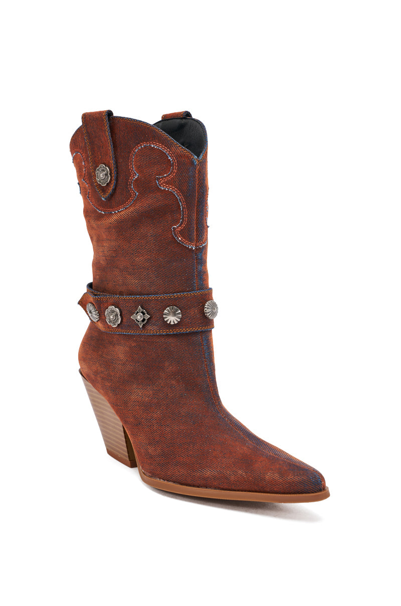The AZALEA WANG NEITH BURNT ORANGE DENIM WESTERN BOOTIE is a mid-calf boot with a pointed toe, angled wooden heel, decorative stitching, and an ankle strap with metal conchos and stud accents. Perfect for styling with chunky heels or denim outfits.