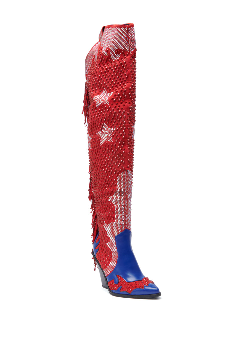 The AZALEA WANG NELLA BLUE MULTI WESTERN EMBELLISHED BOOT is a tall, over-the-knee style with a blue pointed toe, red star and fringe accents, and sparkling rhinestone details for a bold Western-inspired look.