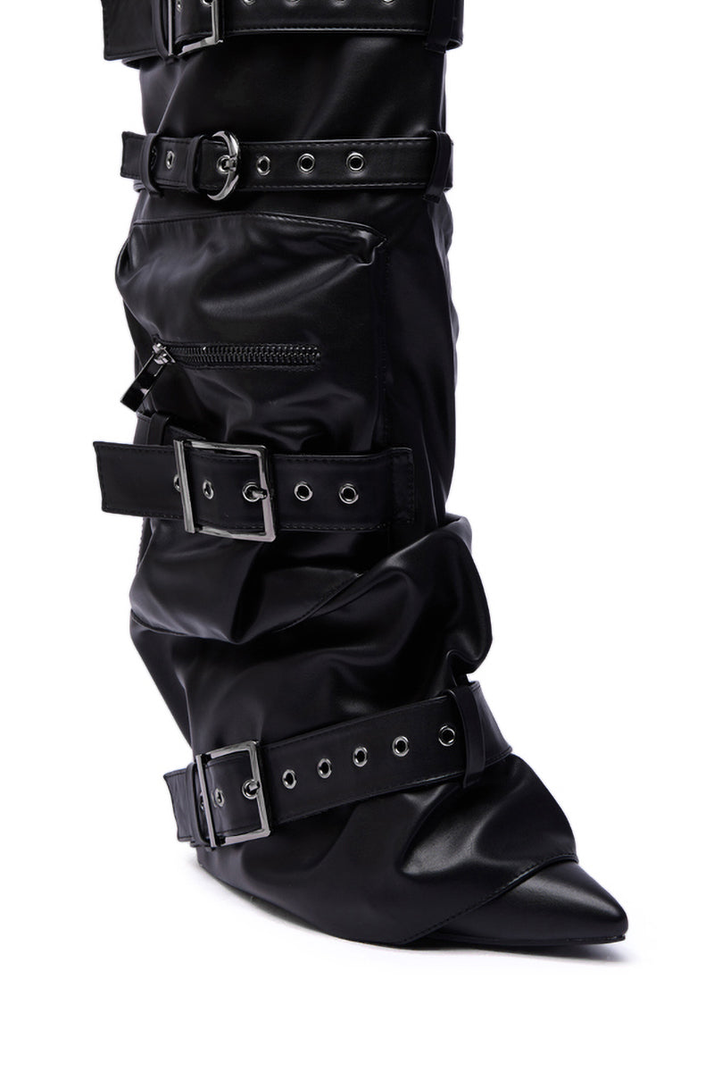 A close-up of the AZALEA WANG NEMIANA BLACK BELT AND BUCKLES DETAIL BOOT, featuring glossy black faux leather, multiple wide buckle straps, a zipper pocket, and a pointed toe with a slouchy yet structured design.