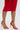 A person wears a red ruffle skirt and the AZALEA WANG NEMTI RED PU WITH GOLD EMBELLISHMENT SANDAL, featuring faux leather and gold ankle straps, standing on a white surface.