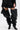 A person in a short black pleated skirt and AZALEA WANG NEMY BLACK KITTEN HEEL THIGH HIGH BOOT with pointed toes, holding a small black handbag.