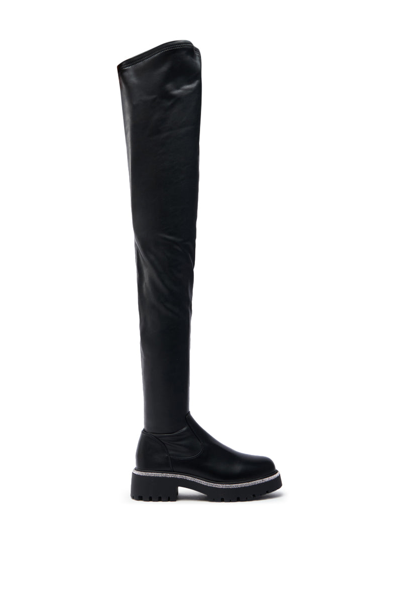 The AZALEA WANG NEWRULES RHINESTONE STRETCH PU FLAT BOOT is a black thigh-high boot with a smooth, sleek finish, thick treaded sole for grip, and rounded toe, shown from the side against a white background.