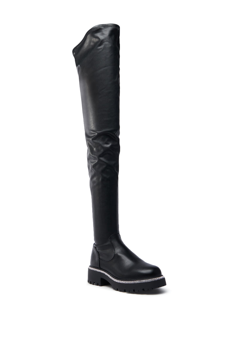 The AZALEA WANG NEWRULES RHINESTONE STRETCH PU FLAT BOOT, a tall black leather thigh-high with a chunky heel, round toe, and sleek design, is displayed on a plain white background. It elegantly blends style and comfort for a sophisticated look.