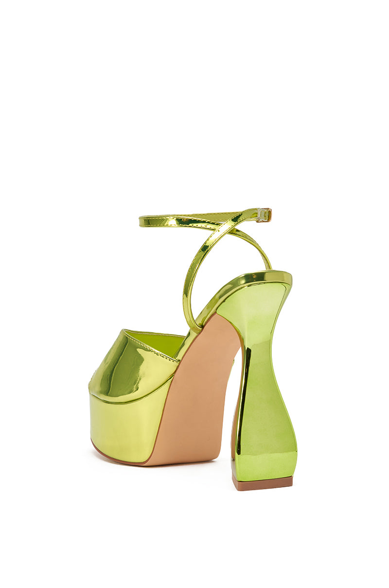 The AKIRA GOLD NEWTON GREEN BLOCK HEEL SANDAL is a shiny metallic green party heel with an ankle strap, chunky sole, and sculpted block heel, shown against a white background. 4