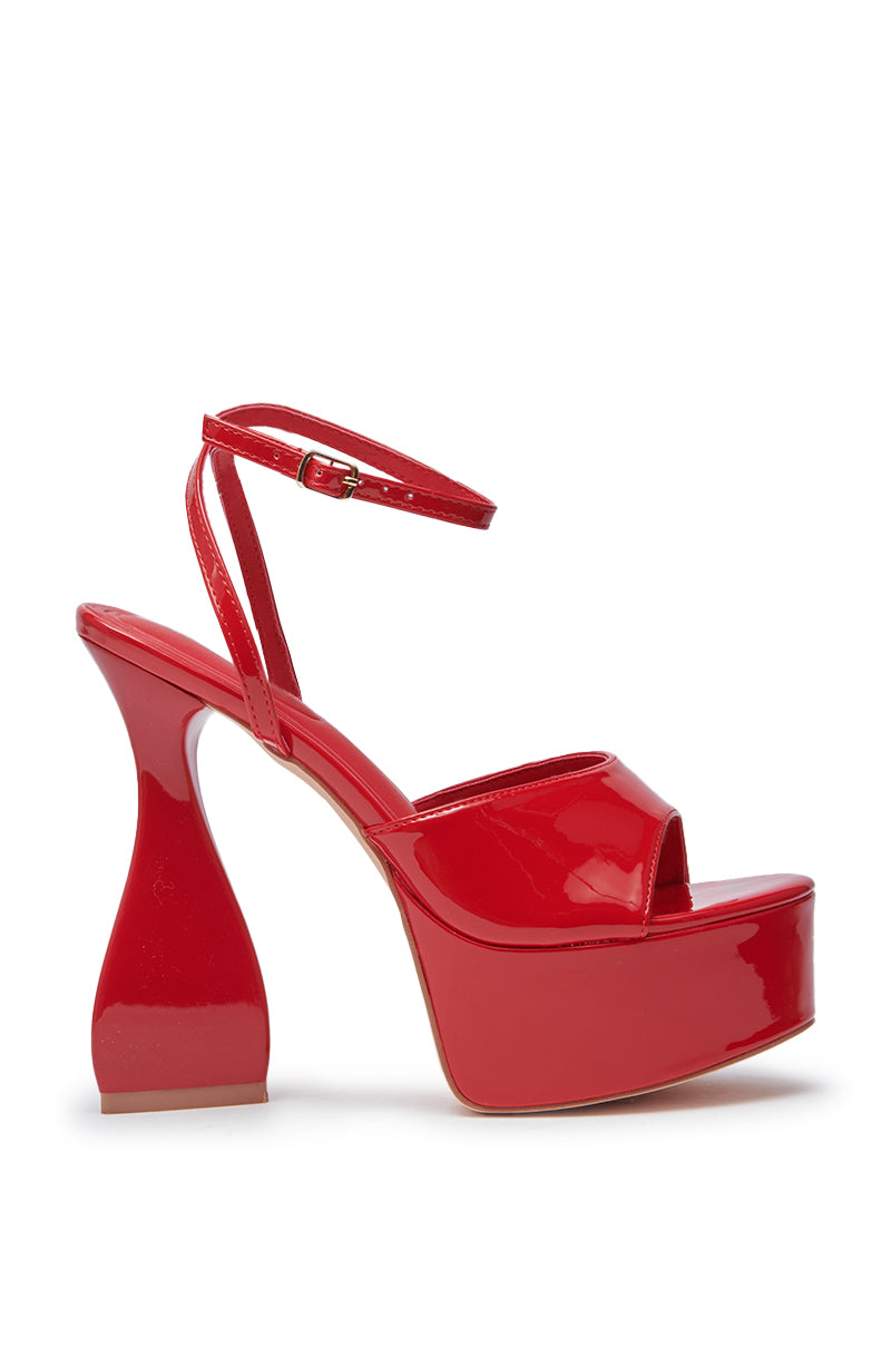 The AZALEA WANG NEWTON RED CHUNKY PLATFORM SANDAL features red faux patent leather, an open toe, ankle strap, platform sole, and a distinct curved flared chunky heel.