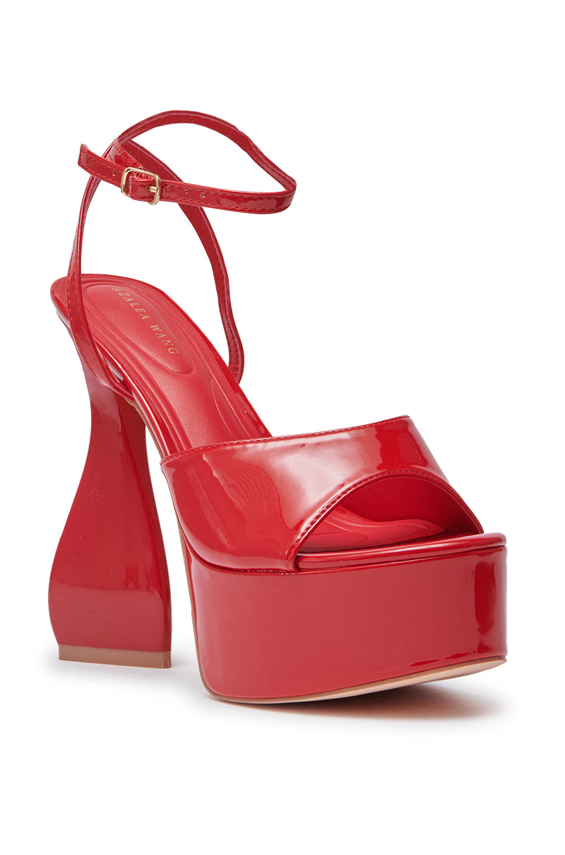 The AZALEA WANG NEWTON RED CHUNKY PLATFORM SANDAL features a shiny faux patent leather finish, flared chunky heel, ankle strap, thick platform sole, and open toe for a bold statement look.