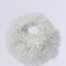 A round, fluffy white IN A FLURRY FAUX FUR BAG with a shaggy texture, resembling soft wool. Perfect as a holiday party accessory, this faux fur delight sits elegantly against a plain white background.