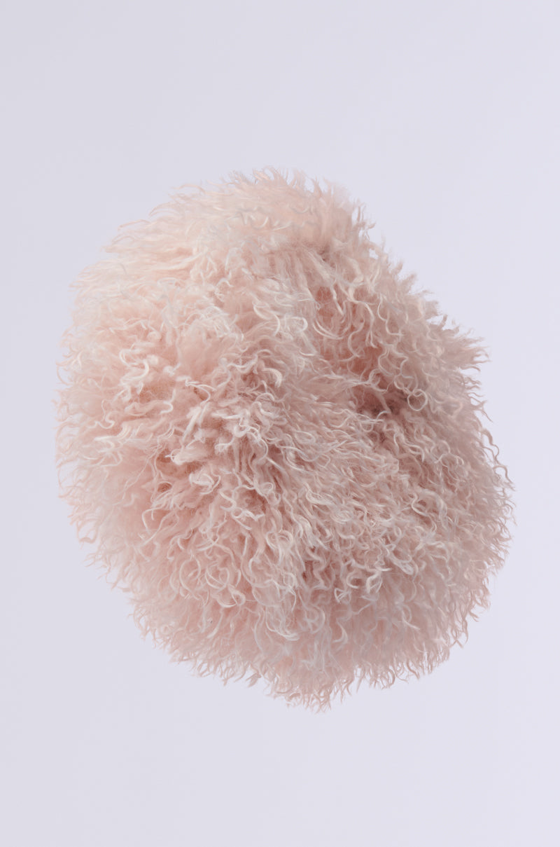 The CURLY Q FAUX FUR PURSE, with its light pink, soft curly texture resembling shaggy faux fur, is displayed against a plain white background, resembling a fluffy pom-pom or cloud.